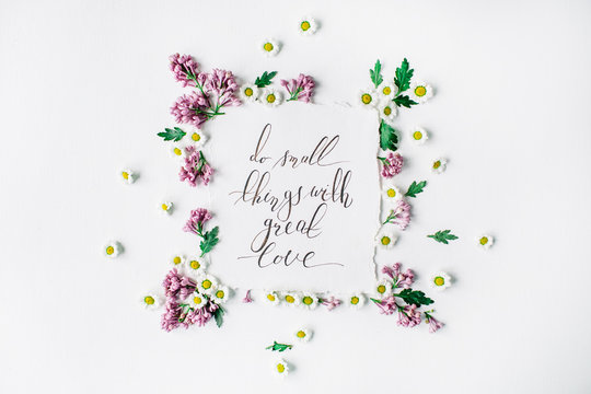 Phrase "Do small things with great love" written in calligraphy style on paper with wreath frame with lilac and chamomile isolated on white background. flat lay, overhead view, top view