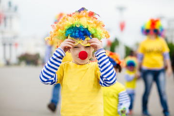 Little boy in clown costume outdoors at summer day