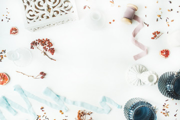 frame with candlesticks, blue ribbon, dry oranges and rowan branches isolated on white background. flat lay, overhead view