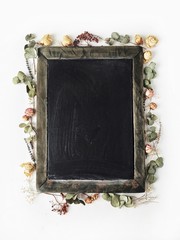 Clean black wooden chalkboard with yellow and pink roses and green leaves