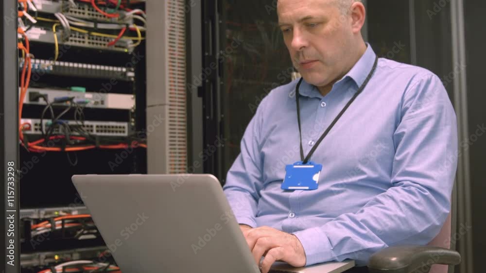 Poster technician using laptop to analyse server