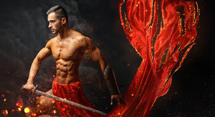 Artistic portrait of muscular male in red waving fabric.
