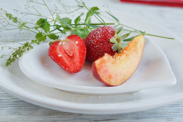 Strawberry and peach with mint on a white heard shape plate