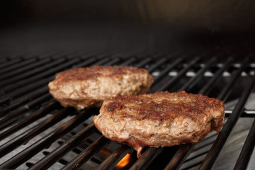 Hamburger patty on gas grill