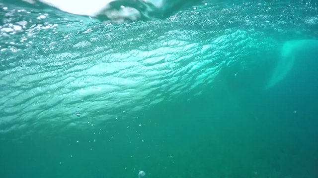 UNDERWATER SLOW MOTION: Extreme pro surfer riding big barrel wave
