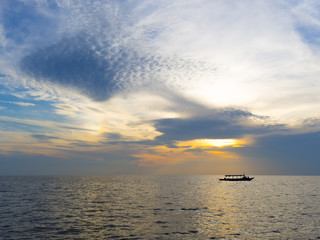 Naklejka na ściany i meble Boat silhouette with sunset sky