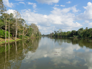 Fototapeta na wymiar River landscape, trees and clouds in blue sky
