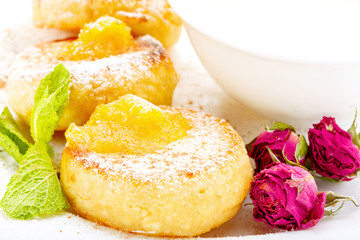 Cheesecakes on a white plate with sour cream
