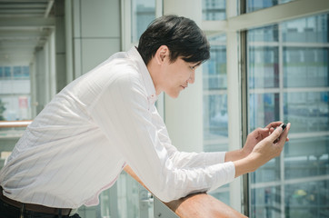 Fototapeta premium asian man. businessman looking on mobile phone in modern office