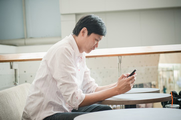 asian man. businessman looking on mobile phone in modern office