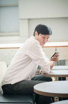 asian man. businessman looking on mobile phone in modern office