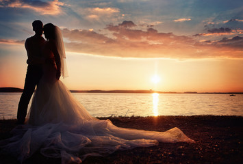 bride and groom together on a background sunset