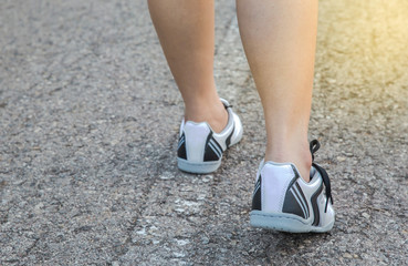 young fitness woman legs walking on road trail