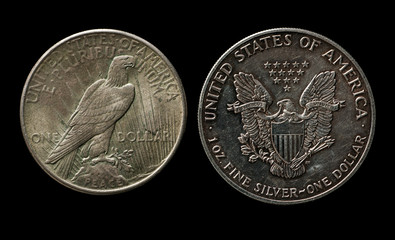 Two silver american dollars with eagle isolated on black