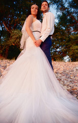 bride and groom look at the sunset