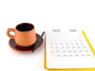 Obraz na płótnie Canvas cup of coffee with saucer and desk calendar with days and dates in July 2016 and blank notes for monthly planning isolated on white background