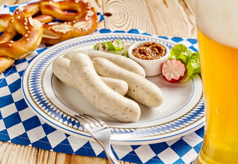 Four sausages with dipping sauce, pretzel and beer