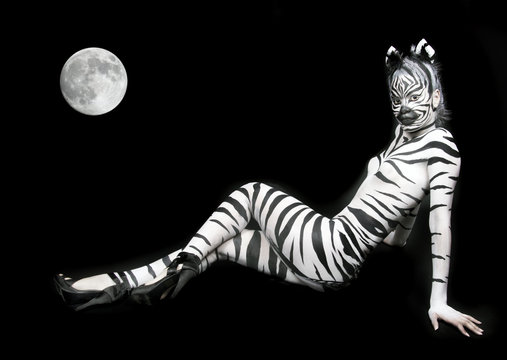 a beautiful girl with zebra body paint with full moon background