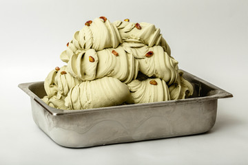 Pistachios ice cream in the metal tray on white background