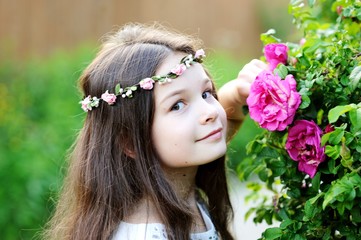 Naklejka premium Little girl smelling peony flower