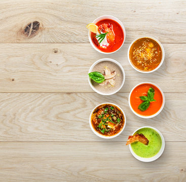 Six soups at wood, top view with copy space