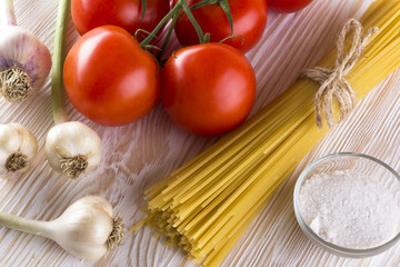 Raw pasta and ingredients with tomatoes , garlic