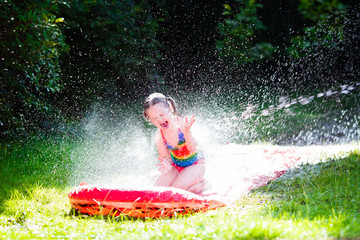 Child playing with garden water slide
