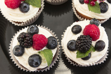 Elegant Cupcakes with Berries on the Black Plate