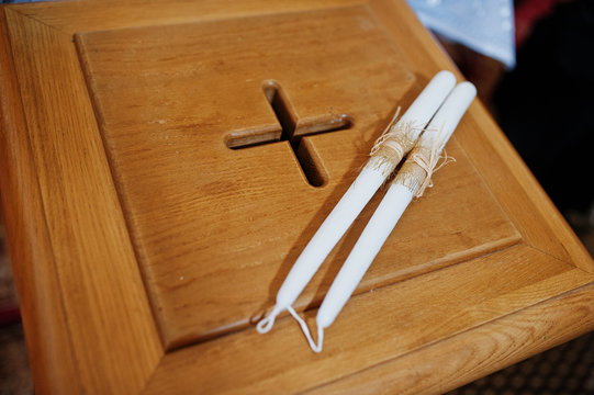 Two candles at wooden chest with cross at church