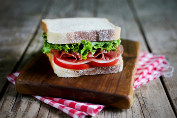 Prosciutto and cheese toast sandwich with tomatoes and lettuce - 115749885
