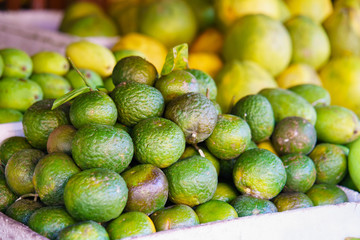 Asian street farmer market selling fresh green mandarin in Vietnam