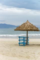 Sunbeds and Palm shelter in China Beach in Da Nang