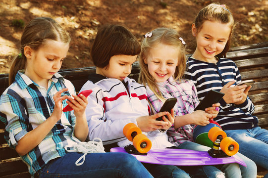 Group of children posing with mobile devices
