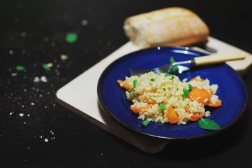 Dietetic rice porridge with Dried apricots and mint leaves in a blue plate