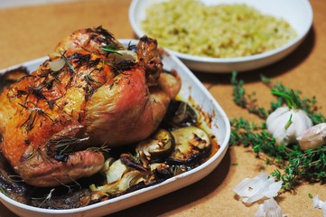 Delicious chicken baked with eggplant and shallots until Golden brown in the oven, with a side dish of barley porridge, garlic and rosemary on a white plate.