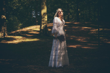 Blonde bride catching sunlight in forest