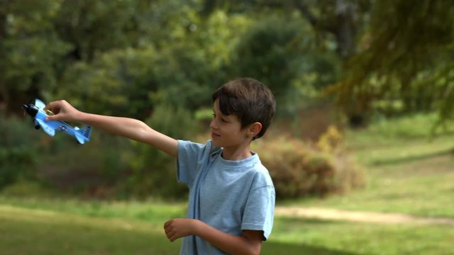Little boy playing with a toy plane at park