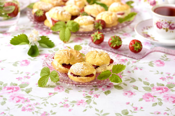 Cream puffs or profiterole filled with whipped cream,g served with strawberries