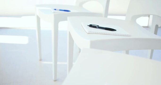 Notebook with pen on white chair