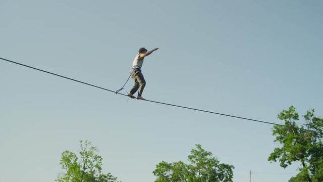 Man slacking on highline above the big urban city