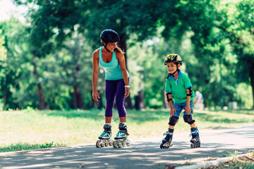 Mother and son roller skating in the park