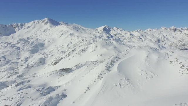 AERIAL: Ski resort in the middle of big mountain range