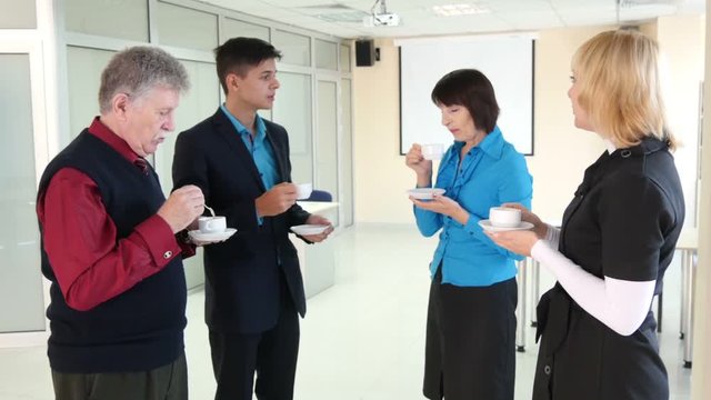 Group of businesspeople having coffee during break in office