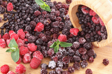 Frozen berries on a wooden table, covered with ice
