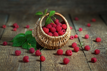 Ripe raspberry in a basket on wooden table