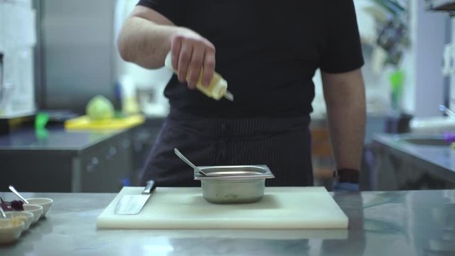 Chef prepares a meat dish in the kitchen of a restaurant