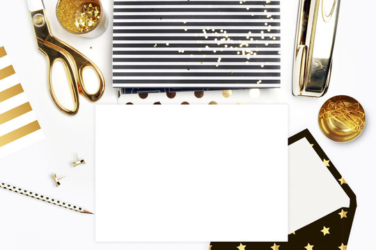 Flat lay, office white desk and envelope with gold stationery. Gold stapler, stripe gold pattern, pencil. View top. Table up. Mock-up background