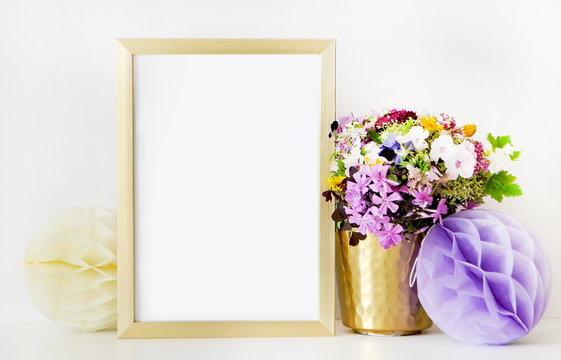 Gold frame mock-up, and white wall with gold vase, and flowers. Place work