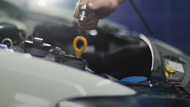 Auto mechanic repair engine at car repair shop. Slow motion