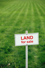 land for sale sign against trimmed lawn background